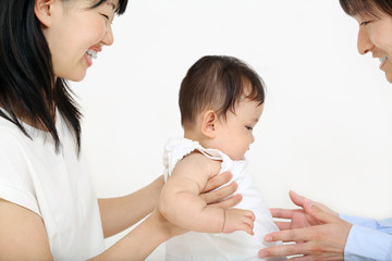 若い夫婦が赤ちゃんを抱き子育てを協力している様子。