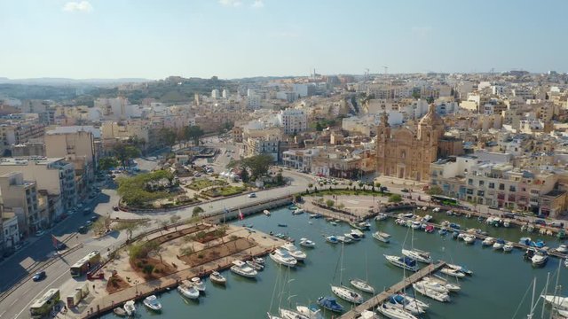 Aerial view of Msida marina, church, yachts, boats. Sunny day. Camera moves forward and turn. Malta country