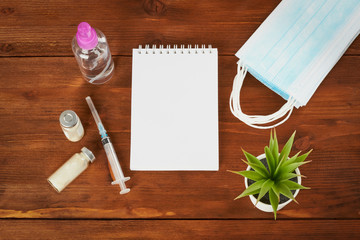Medical diagnosis or prescription doctor layout. Syringe, notepad blank page, medical mask on the doctor desk. Make up