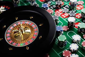 Roulette table in casino. Casino felt green table with red and black numbers. Stack of poker chips.