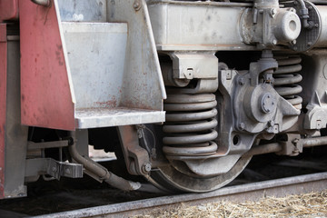 Low angle view of wheel mechanism of modern train locomotive on tracks. Steampunk, techno concept. Railroad transport, travelling, steel constructions