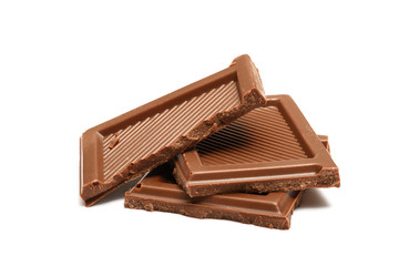 Broken milk chocolate pieces isolated on white background