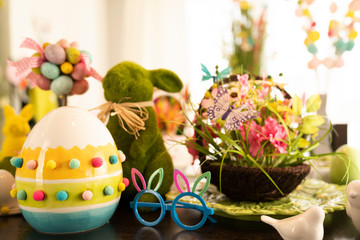 Easter theme. Easter decorations. Easter eggs in basket and easter bunny. Bouquet of spring flowers.