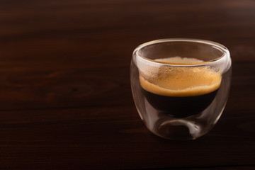 Coffee in a glass cup on wooden background