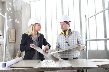 man and woman architect interior designer and foreman worker together with tiles samples and...