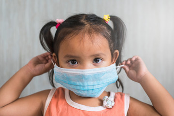 little asian girl wearing a surgical mask. Concept of child heatlh care and infection protection