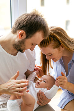 Three-month-old baby in the arms of happy young parents. The most touching moments with father and mother
