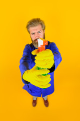 Bearded man with cleaning spray. House clean. Bearded man with broom. Cleaning and disinfection. Professional cleaning. Cleaning service. Clean up. Clearing tools. Housekeeping. Household.