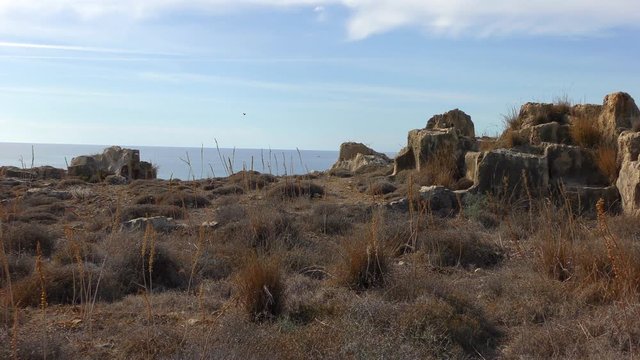 Remains of the walls of the ancient necropolis against the backdrop of the sea