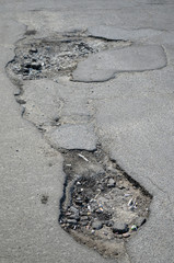 Poor condition of the road surface.  Hole in the asphalt, risk of movement by car, bad asphalt, dangerous road, potholes in asphalt.  Kiev,Ukraine