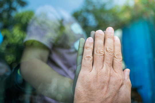 Social distancing among the family, hand of the mother and daughter on a window plane, concept coronavirus,covid-19,Work from home (WFH), Social distancing, Quarantine, Prevent infection concept.