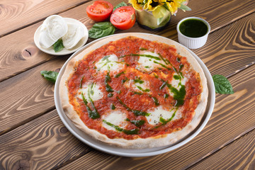 Delicious pizza with cheese, tomatoes, olives and greens