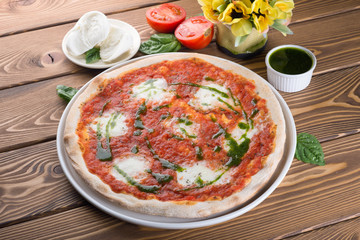 Delicious pizza with cheese, tomatoes, olives and greens