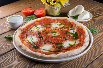 Delicious pizza with cheese, tomatoes, olives and greens