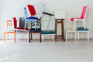 different multicolored chairs in the interior of the white room - obrazy, fototapety, plakaty