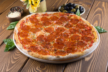 Delicious pizza with cheese, tomatoes, olives and greens