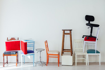 different multicolored chairs in the interior of the white room - obrazy, fototapety, plakaty