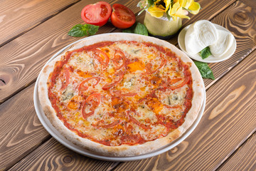Delicious pizza with cheese, tomatoes, olives and greens