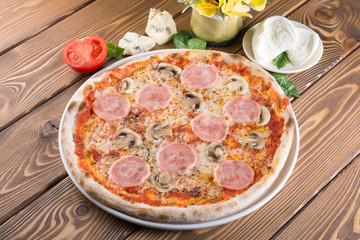 Delicious pizza with cheese, tomatoes, olives and greens