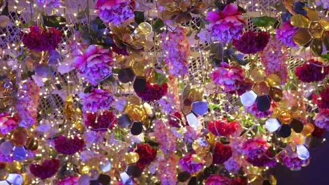 Printemps Haussmann store during Christmas in Paris France, luminous ceiling with thousands of inlluminated colorful flowers
