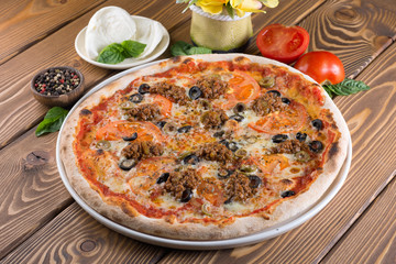 Delicious pizza with cheese, tomatoes, olives and greens