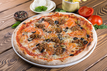 Delicious pizza with cheese, tomatoes, olives and greens