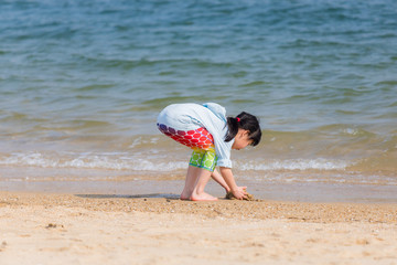 海水浴場で砂遊びをしている可愛い子供