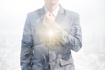 attractive business man smart look in grey suit modern style with double exposure city background. manager leader working success concept.