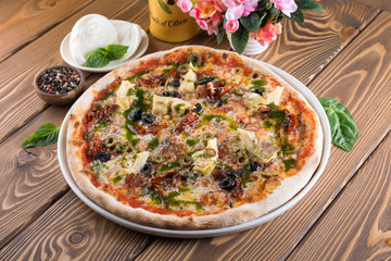 Delicious pizza with cheese, tomatoes, olives and greens