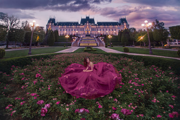 Beautiful woman in roses garden near castle