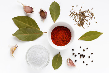set of assorty colorful spices and herbs in bowls on white background, flat lay, top view