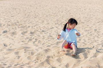 海水浴場で砂遊びをしている可愛い子供