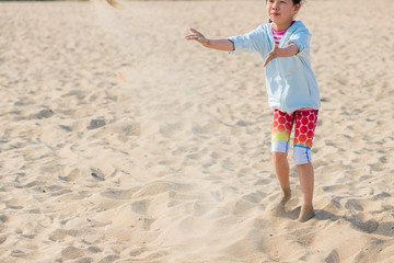 海水浴場で砂遊びをしている可愛い子供