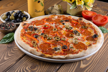 Delicious pizza with cheese, tomatoes, olives and greens