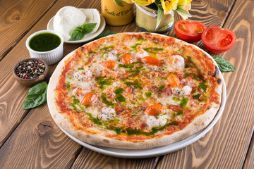 Delicious pizza with cheese, tomatoes, olives and greens
