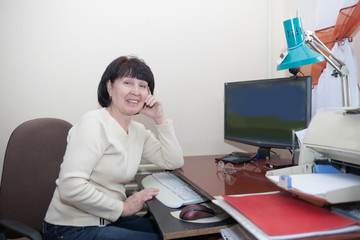 Portrait of   elderly woman at home computer.