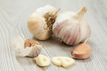 Raw garlic bulbs on a gray wooden background.