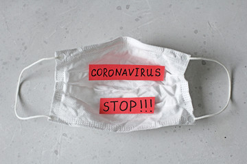 Medical mask on which word Coronavirus is written. Surgical used mask with rubber ear straps....
