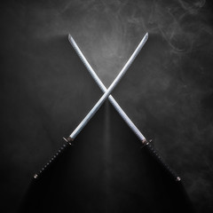Two katanas with crossed blades in dramatic smoke