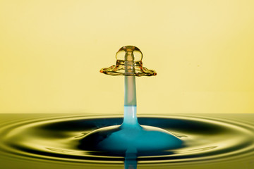 water droplets - beautiful collision of colored water drops on yellow background