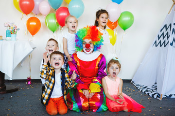 Obraz na płótnie Canvas Children play with a clown