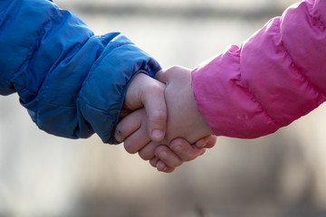 Hands and hearts of children together. Close-up of friendly children holding hands