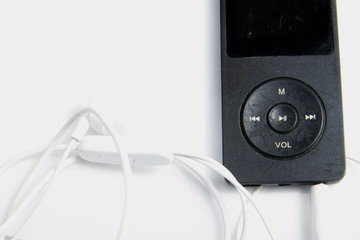Rustic black music player with white earphone on an isolated background