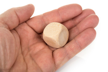 Wooden dice in the hand on a white background