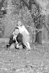 Children Protection Day. Happy family concept. Kids have fun in the park where blossoming cherry flowers. Family day. Black and white portraits