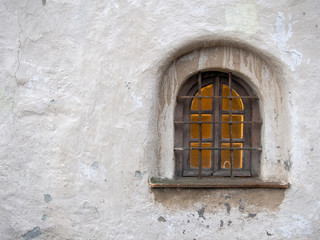 Fototapeta na wymiar Arch window in old stone wall of medieval castle, horizontal image with copy space