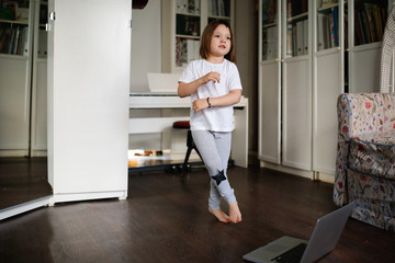 Fototapeta na wymiar child dancing,aerobics in online video chat laptop