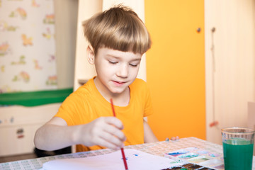 Preschooler kid enjoying his painting. spending time at home
