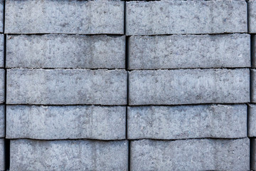 grey textured background, border stone, laid in a stack, side view