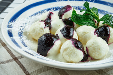 Traditional Ukrainian lazy dumplings. Dumplings with cottage cheese in a white plate on a white wooden background with berry jam. Tasty and sweet breakfast. Vareniki
